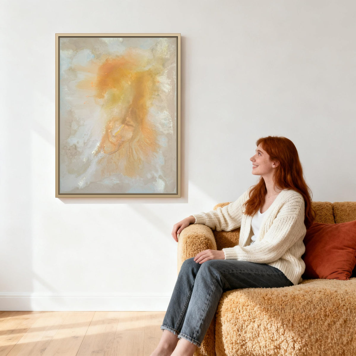 Evening Glow im Wohnzimmer über sandbeigem Sofa, Betrachterin auf der Sofalehne zum Bild gewandt