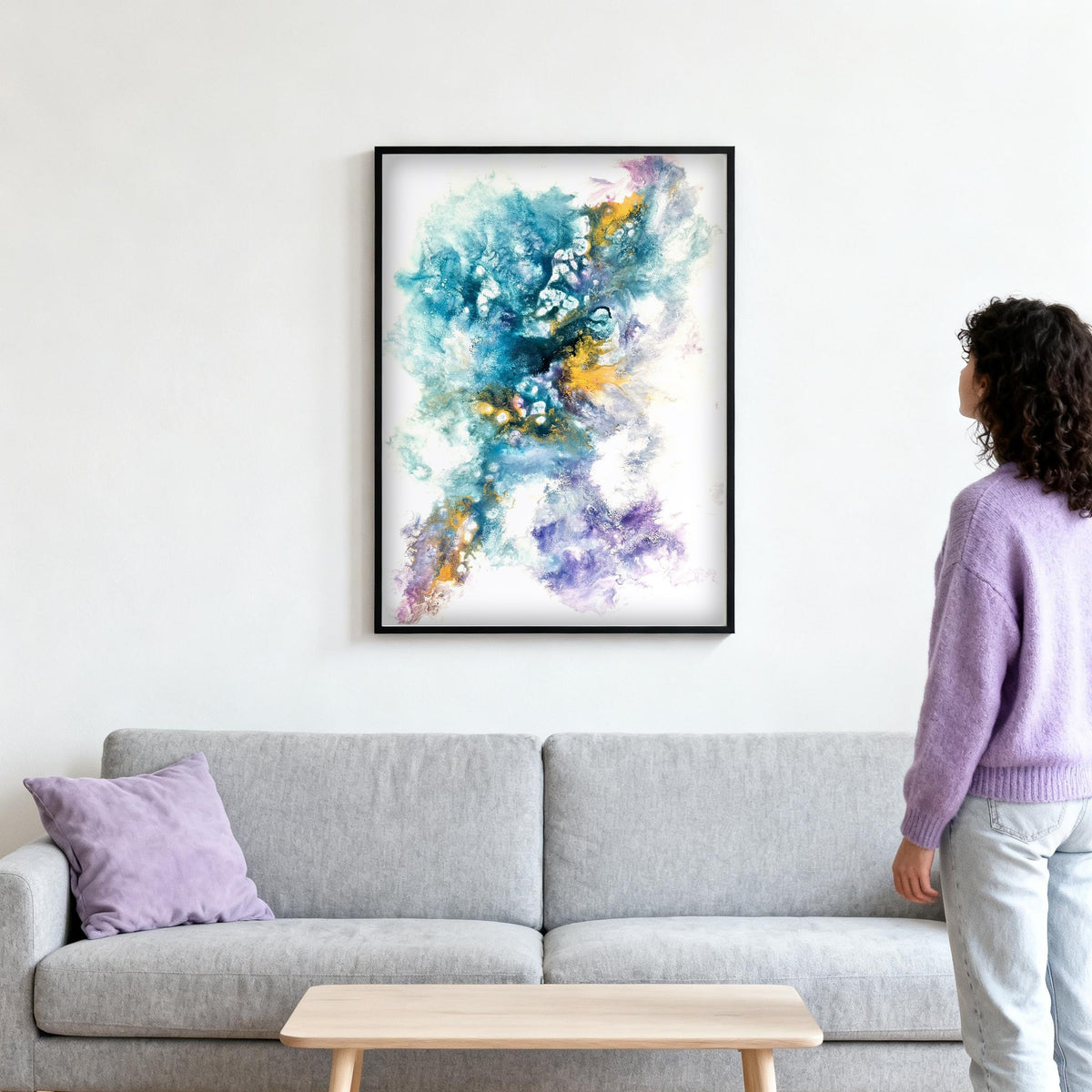 Holi Harmony – Gemälde im hellen Wohnzimmer über dem Sofa, Betrachterin vor dem Werk