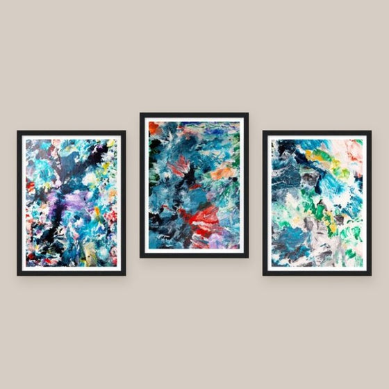 Three framed art prints side by side on a beige wall