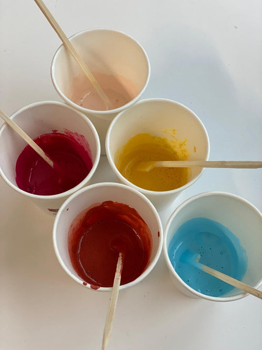 Becher mit roter, gelber, blauer und rosa Farbe – Malkurs für Kinder in Eindhoven